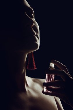 silhouette of girl spraying perfume on her neck, isolated on black clipart