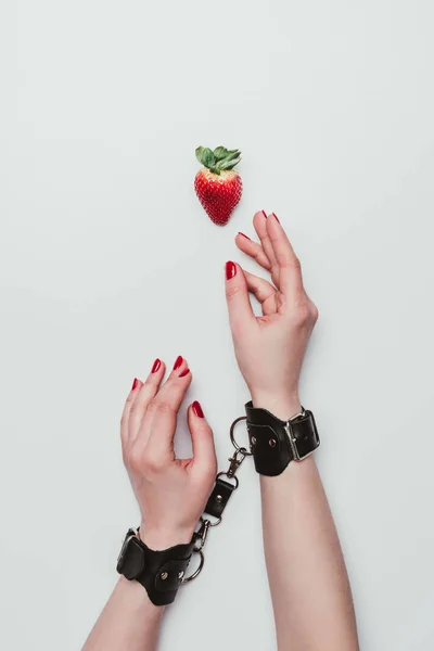Kvinnliga Händer Bundna Med Läder Handbojor För Strawberry Isolerad Vit — Stockfoto