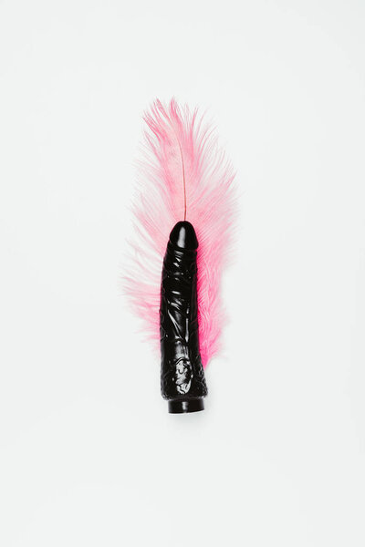 Black dildo toy with pink feather isolated on white