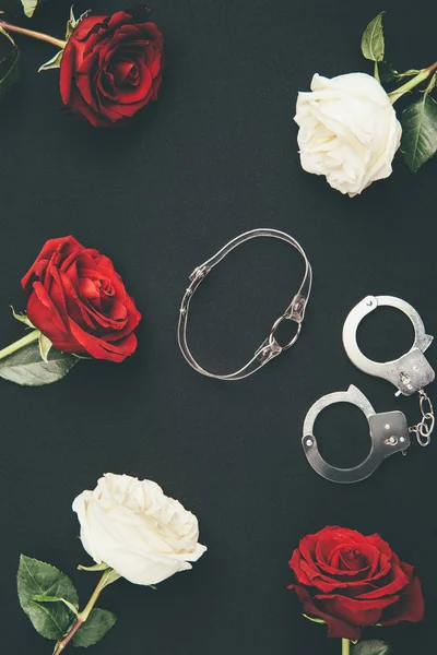 Kragen Und Handschellen Mit Rosenblüten Isoliert Auf Schwarz — Stockfoto
