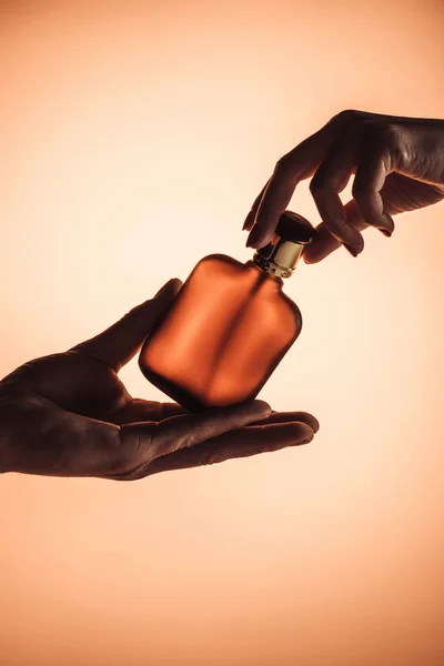 Vista Recortada Manos Masculinas Femeninas Con Frasco Perfume Aislado Naranja — Foto de Stock