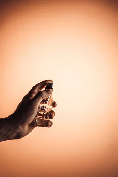 Beskuren Bild Mannen Holding Sprayflaska Parfym Isolerad Orange — Stockfoto