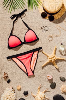 çeşitli aksesuarlar ile şık pembe bikini üst görünümden kum plajındaki