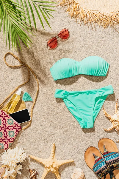 şık bikini ve çeşitli aksesuarlar kumsalda yalan Üstten Görünüm