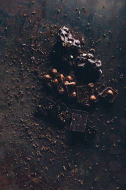 fındık ile çeşitli lezzetli çikolata parçaları üstten görünüm karanlık yüzeyi