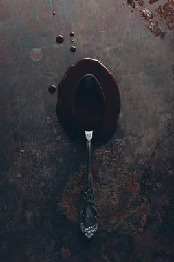 top view of vintage spoon and gourmet melted chocolate on dark surface clipart
