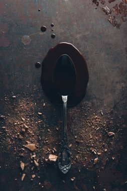 top view of vintage spoon and delicious melted chocolate on dark surface clipart
