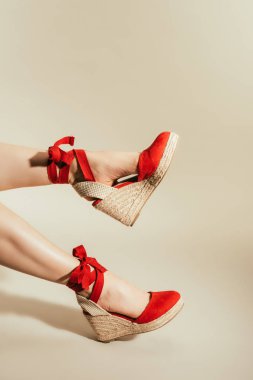 kadın bacak bej renkli arka plan üzerinde şık Kırmızı platform Sandaletler içinde kırpılmış atış