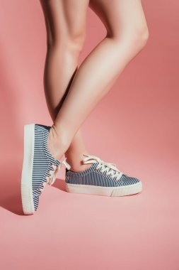 pembe bir arka plan üzerinde şık spor ayakkabı kadın bacak Resim kırpılmış