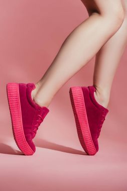 kızın ayak pembe bir arka plan üzerinde duran şık spor ayakkabı içinde kırpılmış atış