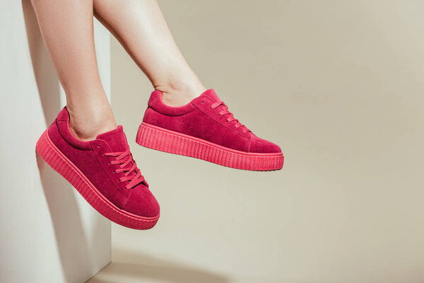 cropped shot of woman feet in stylish stylish sneakers on white background