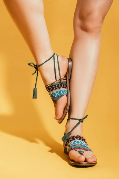 Abgeschnittenes Bild Von Frauenbeinen Stylischen Sandalen Auf Gelbem Hintergrund — Stockfoto