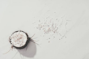 top view of half of coconut and shavings on white clipart