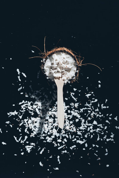 close-up view of fresh natural coconut with shavings on black
