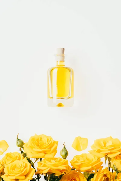 Draufsicht Auf Eine Flasche Parfüm Und Gelbe Rosen Auf Weißem — Stockfoto