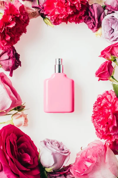 白色玫瑰花蕾包围芳香香水瓶的顶部视图 — 图库照片