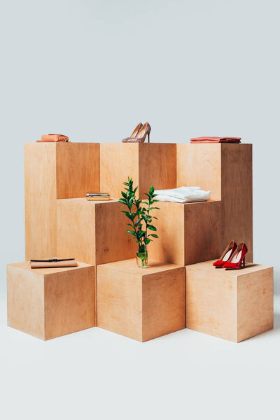 high heels and twigs in vase on wooden stands, summer sale concept
