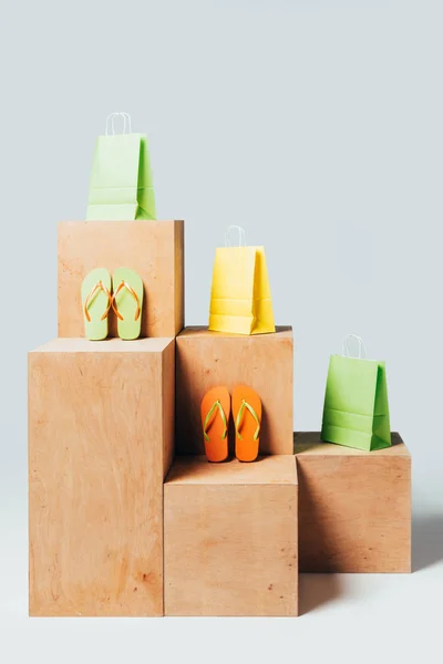 Farbige Einkaufstaschen Und Flip Flops Auf Holzständern Sommerschlussverkauf Konzept — kostenloses Stockfoto
