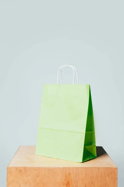 Una Bolsa Papel Verde Claro Soporte Madera Aislado Blanco Concepto — Foto de stock gratis