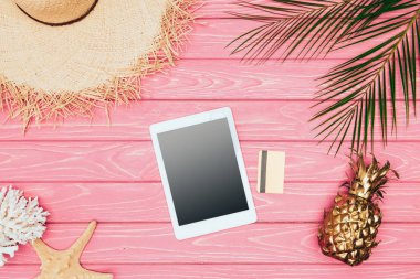 pembe ahşap yüzey üzerinde kredi kartı ve altın ananas ile dijital tablet Üstten Görünüm