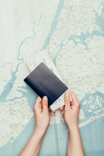 旅行地图上持有机票和护照的妇女被裁剪的照片 — 图库照片