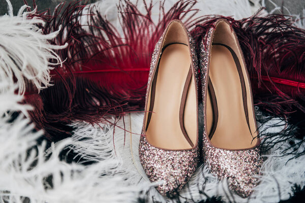 close up view of bridal shoes and decorative feathers for rustic wedding