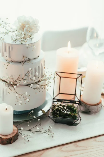 スタイリッシュなテーブル設定キャンドルと素朴な結婚式のための結婚指輪のクローズ アップ表示 — ストック写真