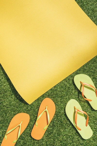 Tendido Plano Con Alfombra Amarilla Chanclas Hierba Verde — Foto de Stock