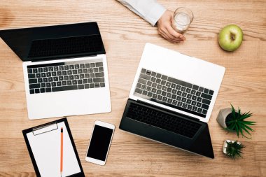 Dizüstü bilgisayarların, akıllı telefonun ve panonun yanında su bardağı tutan işadamlarının en iyi görüntüsü.