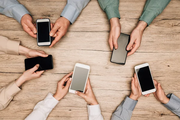 Ovanifrån Affärsmän Som Håller Smartphones Med Tomma Skärmar Bordet Beskärd — Stockfoto