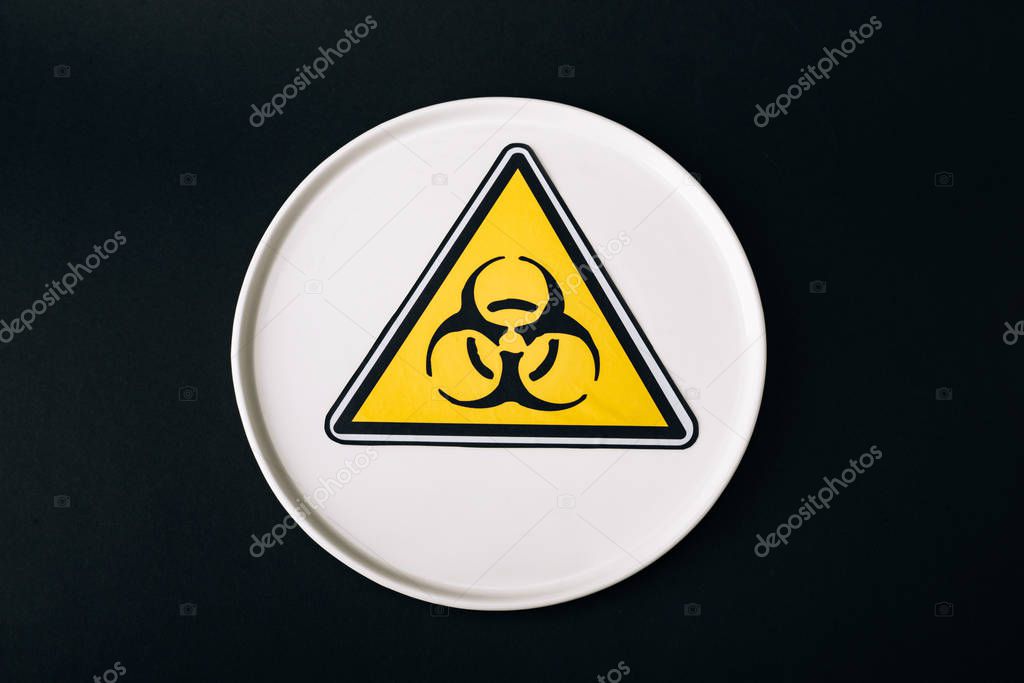 Top view of plate with biohazard sign isolated on black