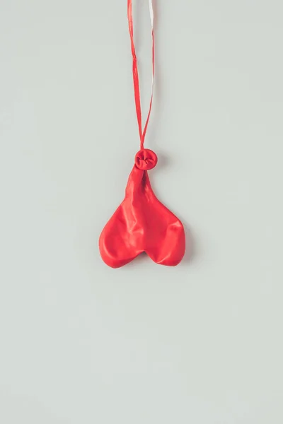 Vista superior de flipped sobre o balão desinflado na fita isolada no conceito branco, dia dos namorados — Fotografia de Stock