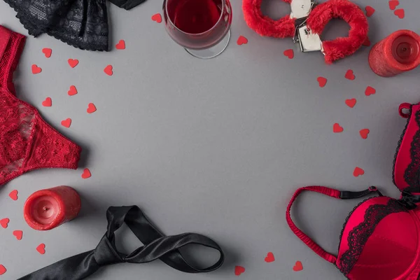 Draufsicht auf Höschen, BH und Handschellen mit einem Glas Wein auf dem Tisch — Stockfoto