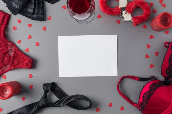 Vue du dessus de la feuille blanche de papier entre les sous-vêtements et le verre de vin — Photo de stock