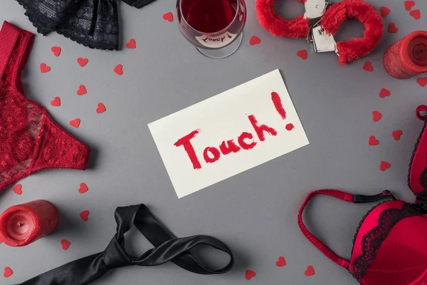 Верхний вид заметки с прикосновением слова между трусиками и наручниками, День святого Валентина концепция — стоковое фото