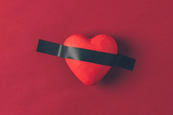 Vista superior del corazón rojo bajo cinta aislante en el concepto rojo, día de San Valentín - foto de stock