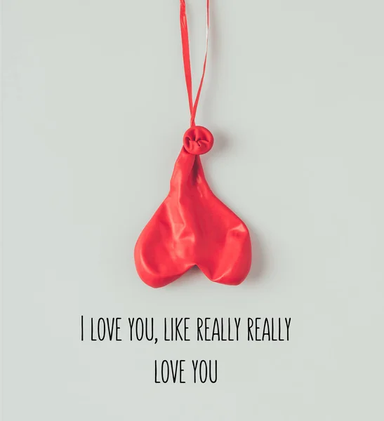 Top view of deflated balloon on ribbon with text i love you like really really love you isolated on white — Stock Photo