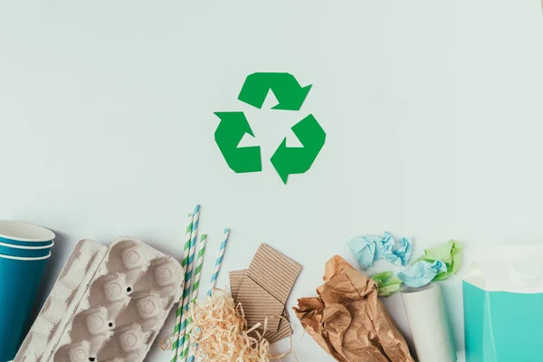Flat lay with various types of garbage and recycle sign isolated on grey — Stock Photo