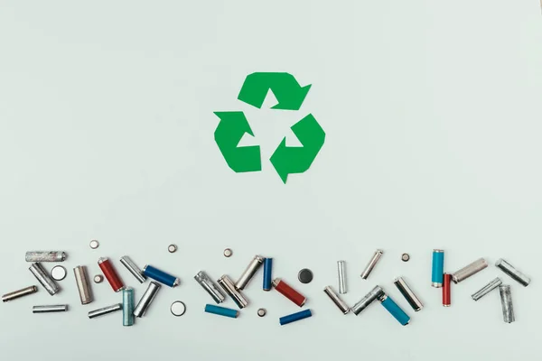 Top view of recycle sign and various types of batteries isolated on grey — Stock Photo