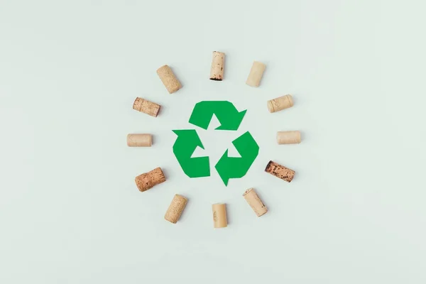 Vue de dessus du panneau de recyclage et bouchons de bouteille autour isolé o gris — Photo de stock