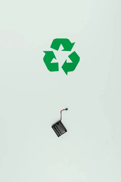 Vista superior del signo de reciclado y del acumulador aislado en gris - foto de stock