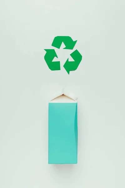 Top view of recycle sign and cardboard package isolated on grey — Stock Photo