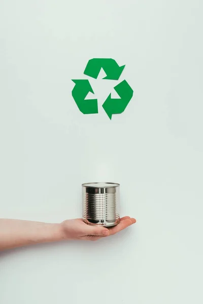 Vista parcial de la lata de sujeción del hombre con signo de reciclado aislado en gris - foto de stock