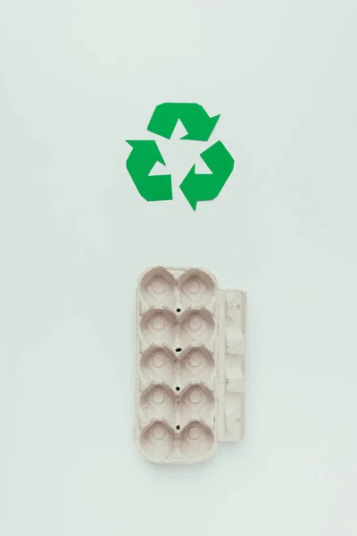 Top view of recycle sign and empty carton egg box isolated on grey — Stock Photo