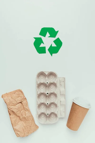 Flache Liege mit Recyclingschild und Einwegmüll isoliert auf grau — Stockfoto