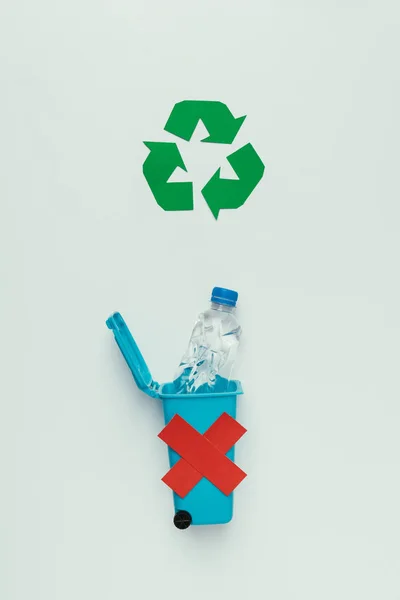 Blick von oben auf Recyclingschild, Mülleimer mit rotem Kreuz und Plastikflasche isoliert auf grau, Recyclingkonzept — Stockfoto