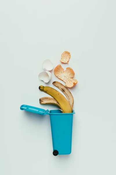 Vista superior de la papelera con desperdicio de alimentos aislado en gris, concepto de reciclaje - foto de stock