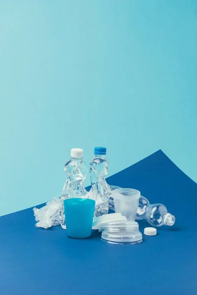 Close up view of various plastic trash on blue background, recycle concept — Stock Photo