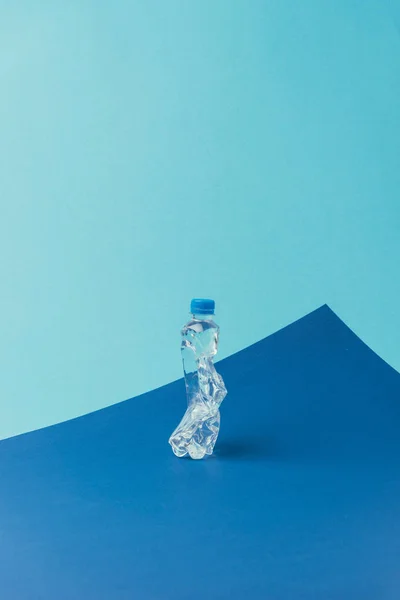 Vista de cerca de la botella de plástico sobre fondo azul, concepto de reciclaje - foto de stock