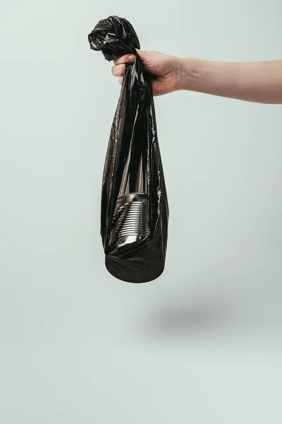 Cropped shot of woman holding garbage bag with can isolated on grey — Stock Photo